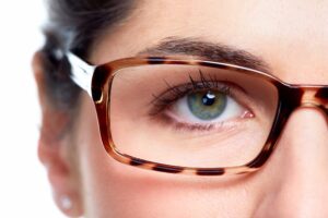 A close-up of an woman wearing stylish, tortoiseshell glasses with a soft focus on the background, highlighting facial features.