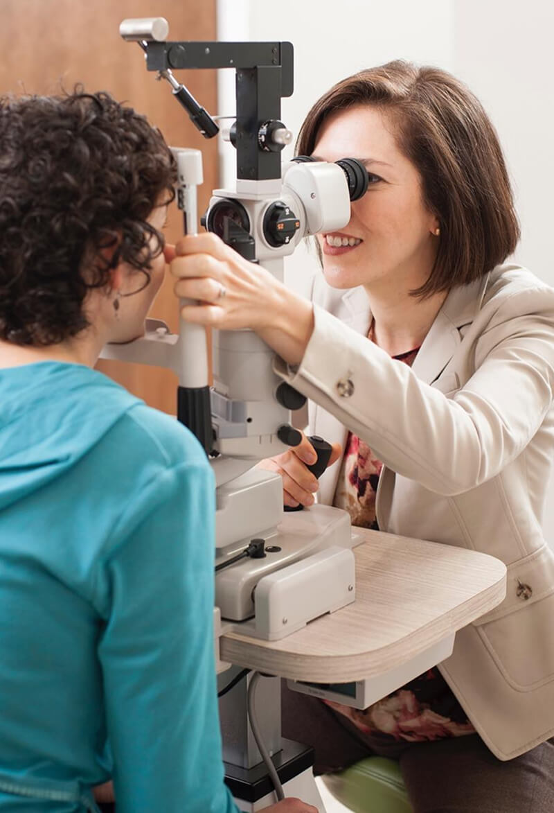 Dr. Vivian Schiedler conducts an eye exam using specialized equipment on a patient.