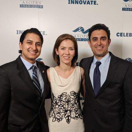 Dr. Vivian Schiedler along with two men in professional suits .