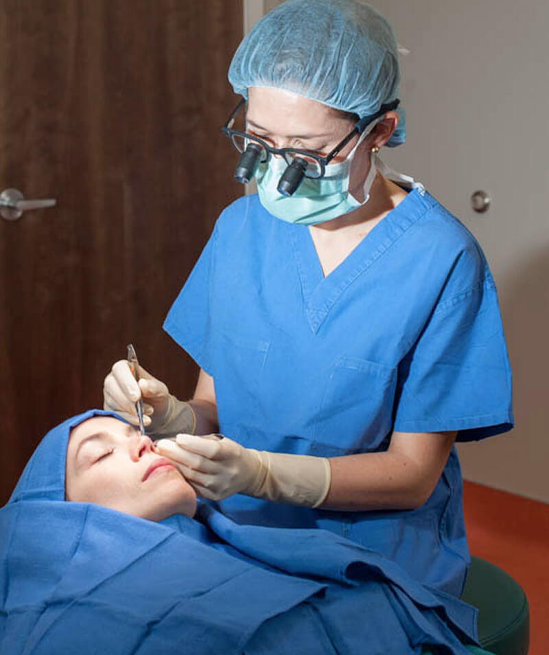 A lady ophthalmologist doing surgery on eye of her lady patient.