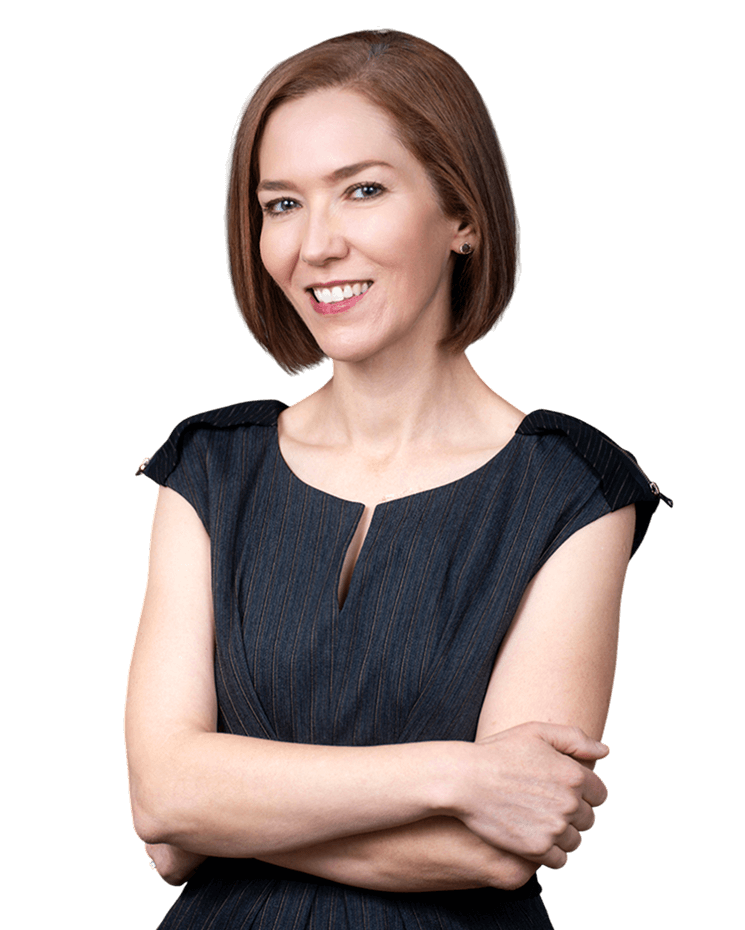 Dr. Vivian Schiedler with short hair wearing a blue dress stands confidently with a smiling face.