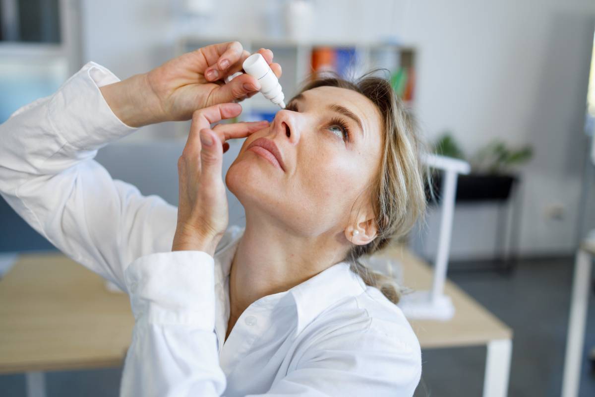 Woman using eye drops.